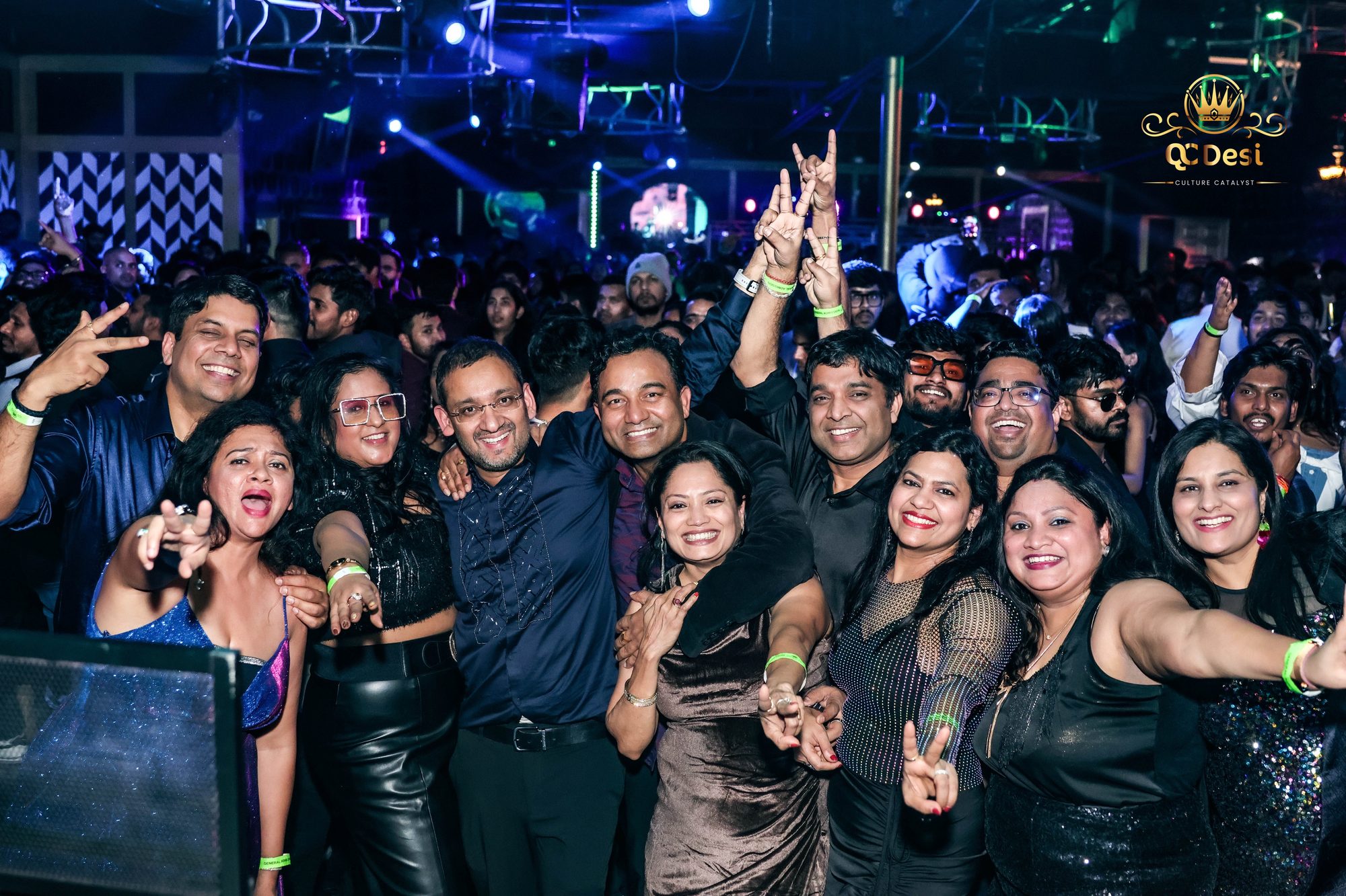 Group of friends cheering for the camera at QCDesi New Year's Eve