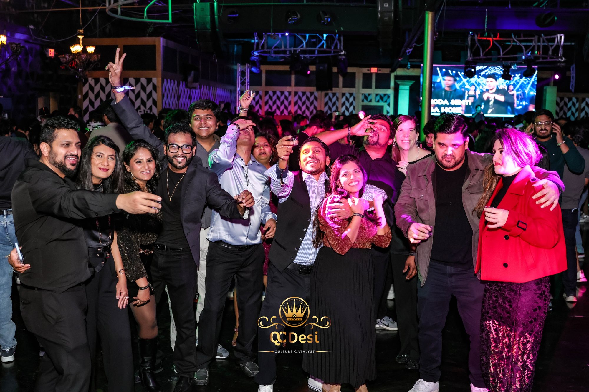 Partygoers in black outfits posing together on the dance floor