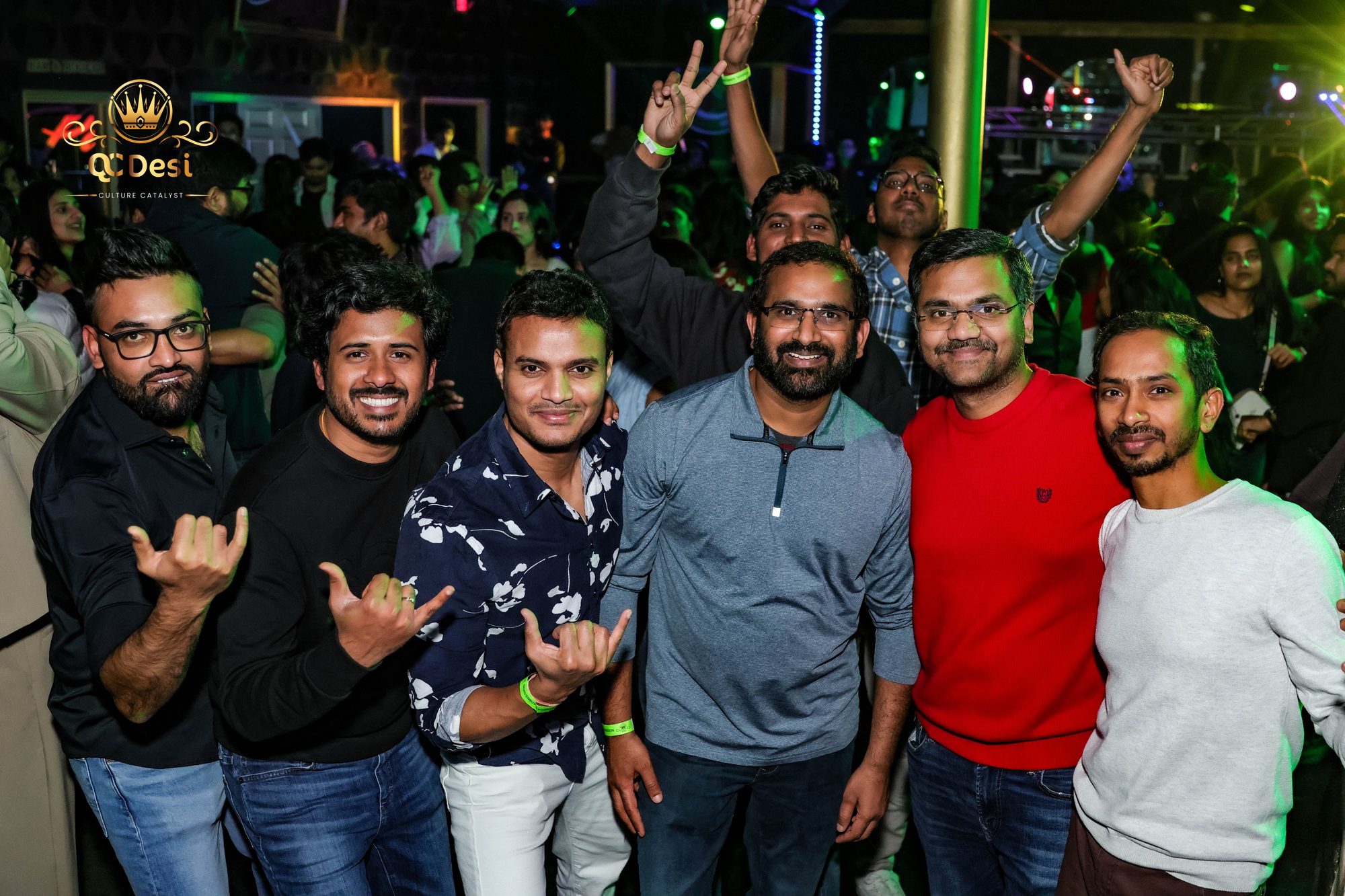 Group of friends cheering for the camera in the crowd